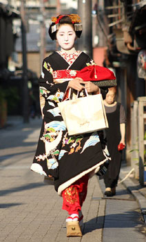 A geisha walks in Gion district. 