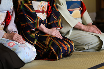 women in kimonos kneeling down